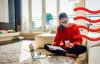 Woman checking letters and her phone while sitting on the floor